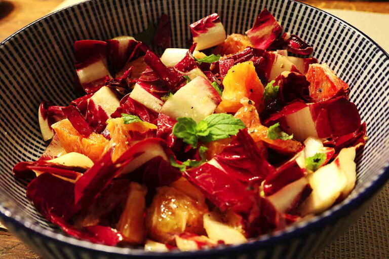 Satt violetter Radicchio Treviso mit Blutorange in Blauer Schüssel